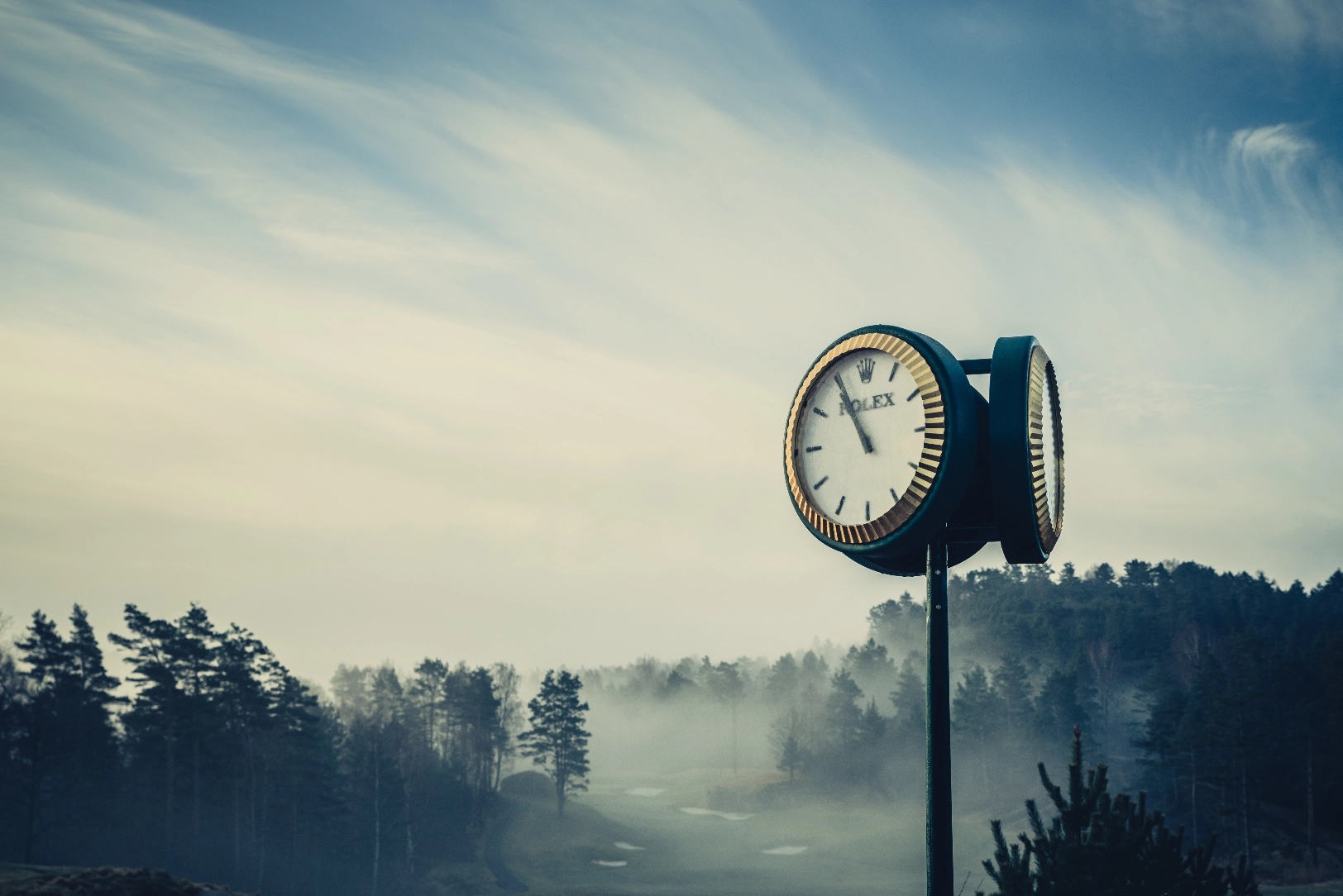 Stolpe med klocka ute i naturen