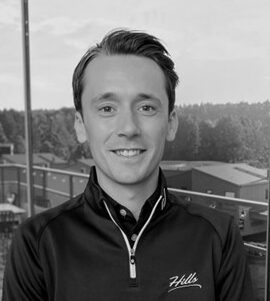 Svartvit bild på man som ler in i kameran